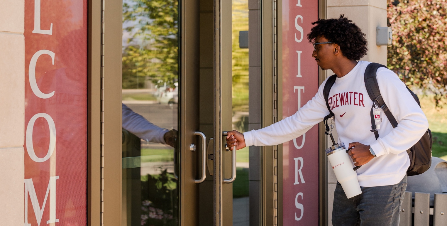 Young student opening the door to Ridgewater College.